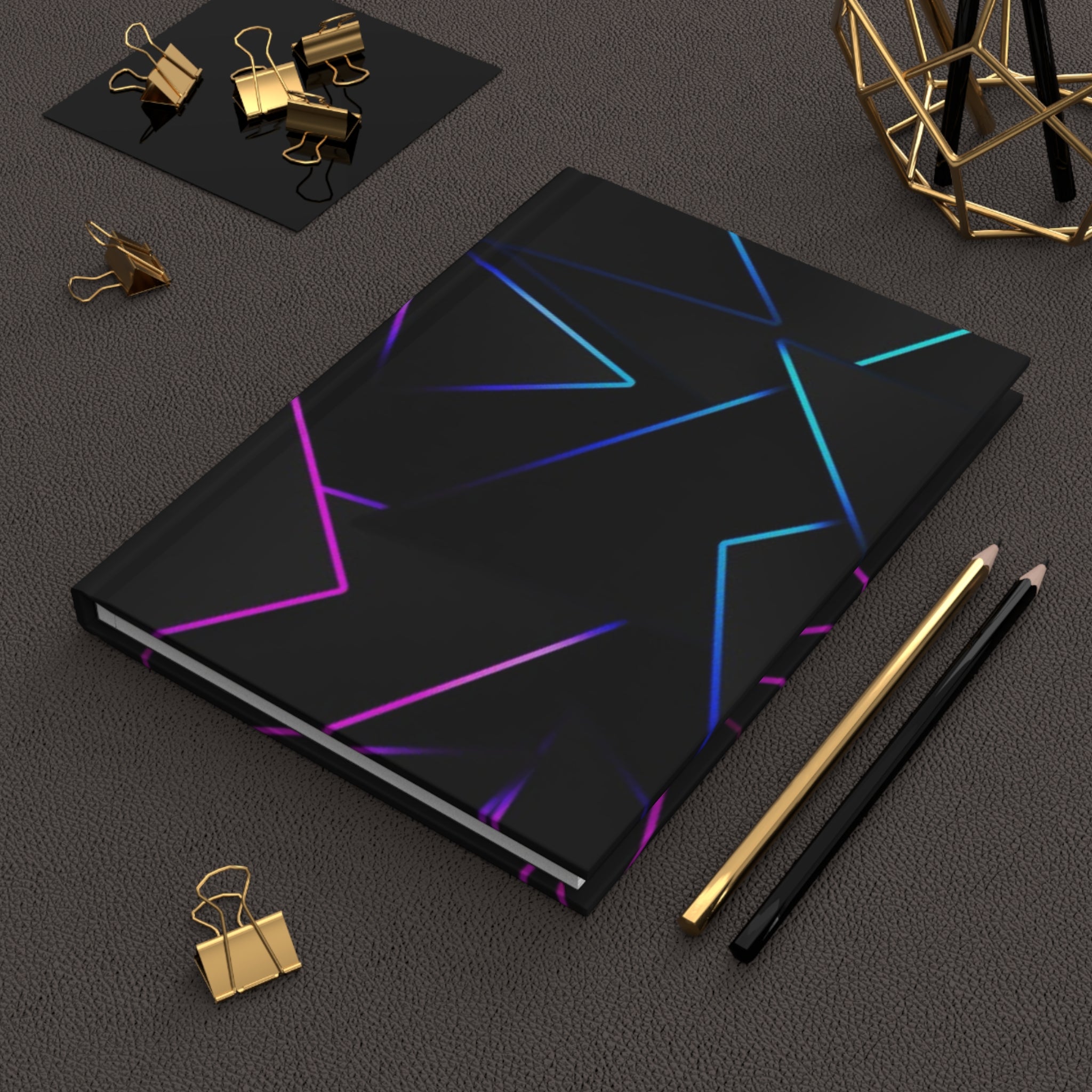 Quaderno hardcover nero opaco con grafica astratta blu e rosa sulla copertina.
