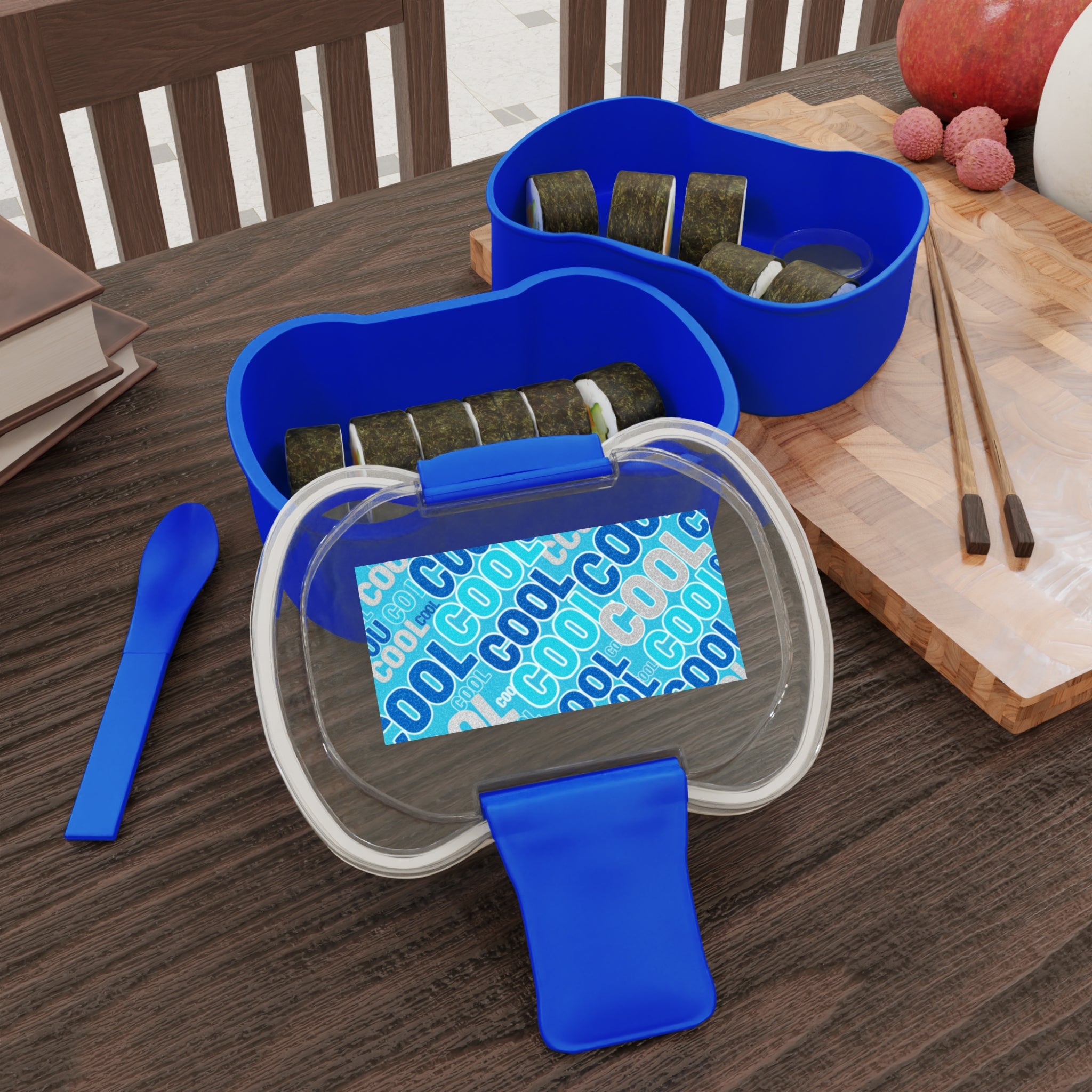 Bento blu a due livelli con coperchio trasparente e due scomparti con cibo.