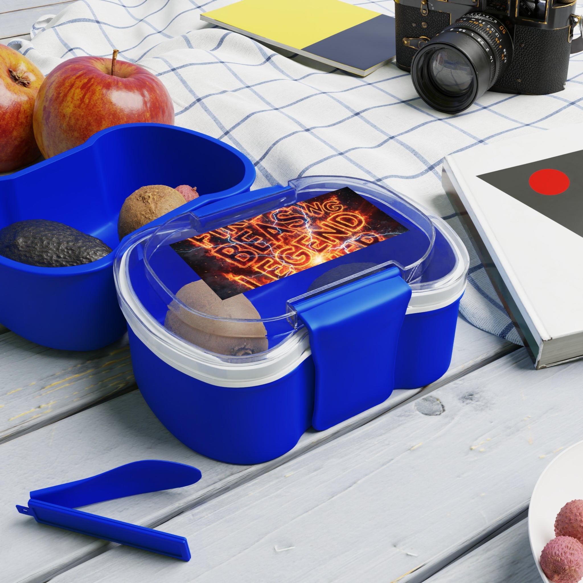 Contenitore bento a due piani blu con coperchio trasparente e posate sul tavolo