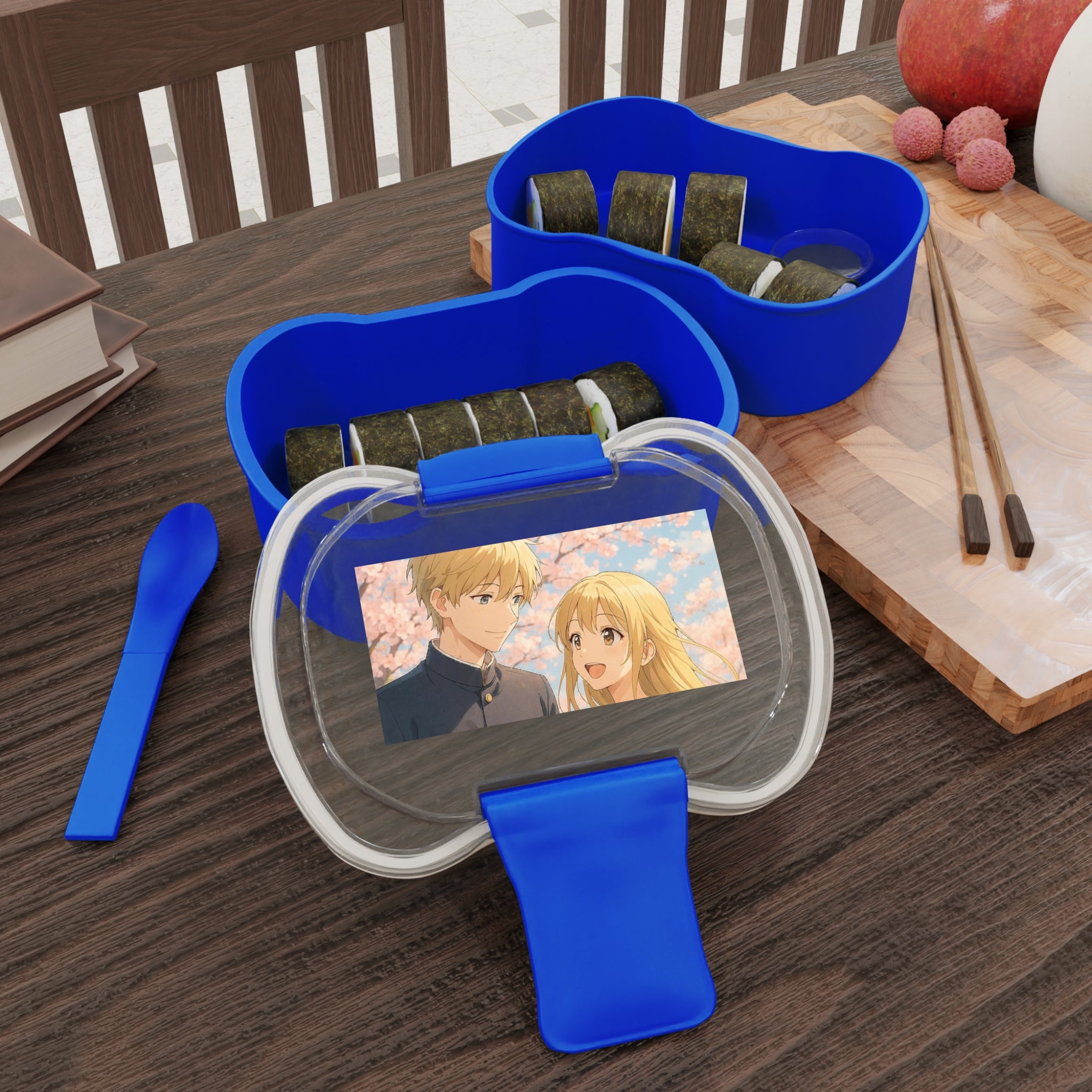 Contenitore bento blu a due livelli con scomparti e due bacchette sul piano
