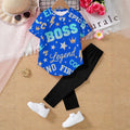 Tuta bambino: maglietta blu con stelle e leggings neri, con scarpe bianche.