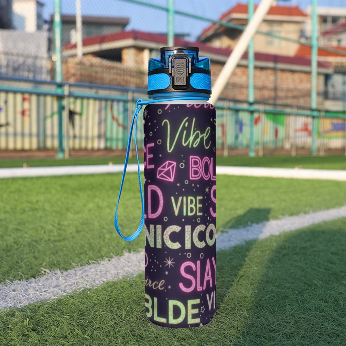 Bottiglia sportiva 32 oz scura con coperchio blu, tracolla e scritte multicolore
