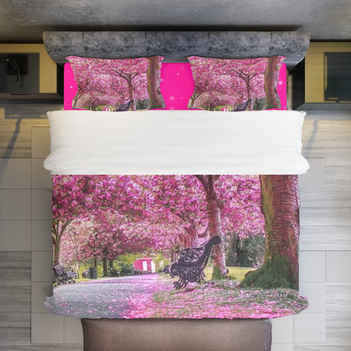 Copripiumino rosa con stampa alberi in fiore, vista frontale sul letto