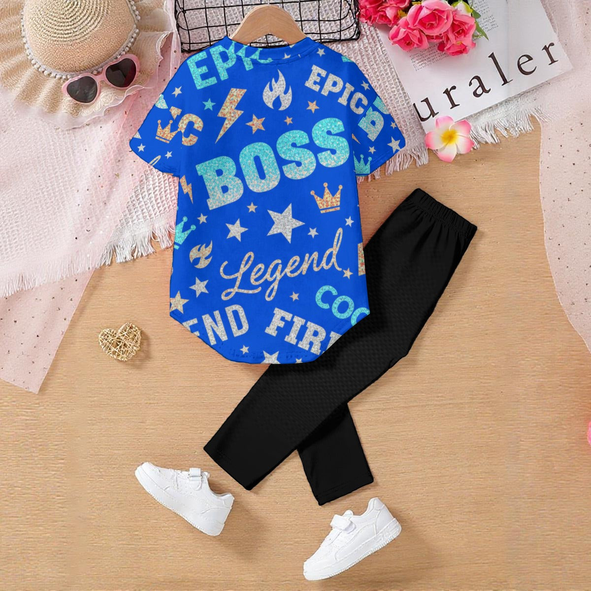 Tuta bambino: maglietta blu a maniche corte con scritte e leggings neri, scarpe bianche.