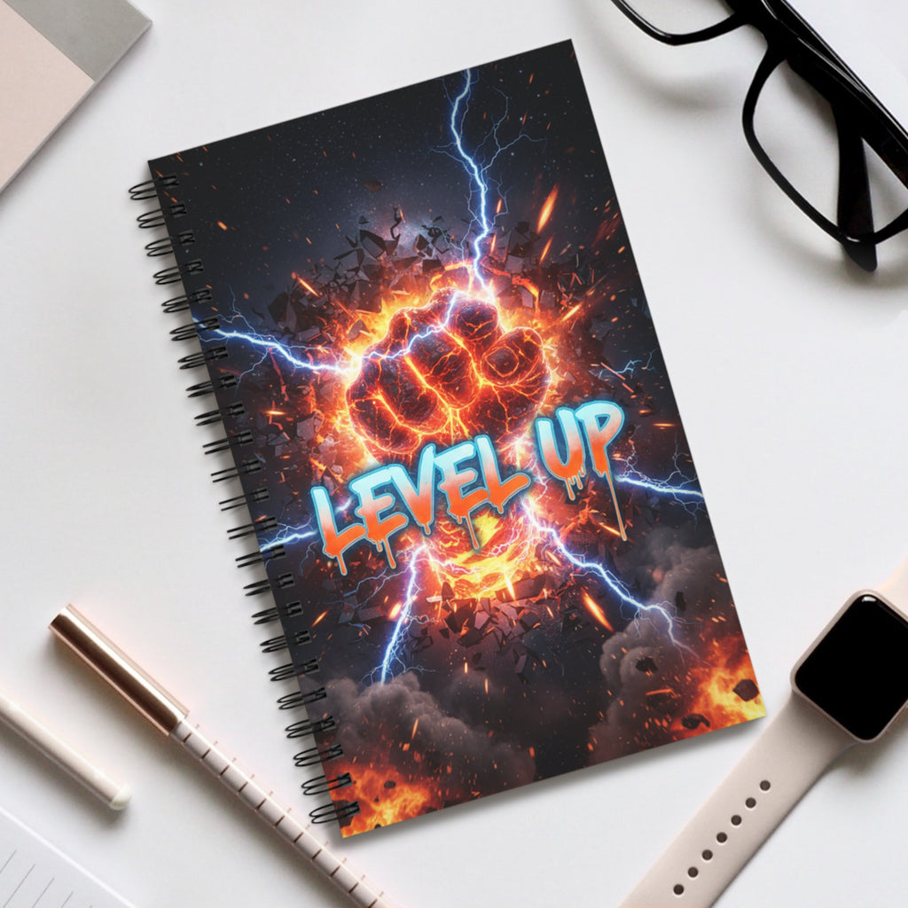 Spiral notebook with dark “LEVEL UP” cover; shown with pen, phone, and glasses nearby
